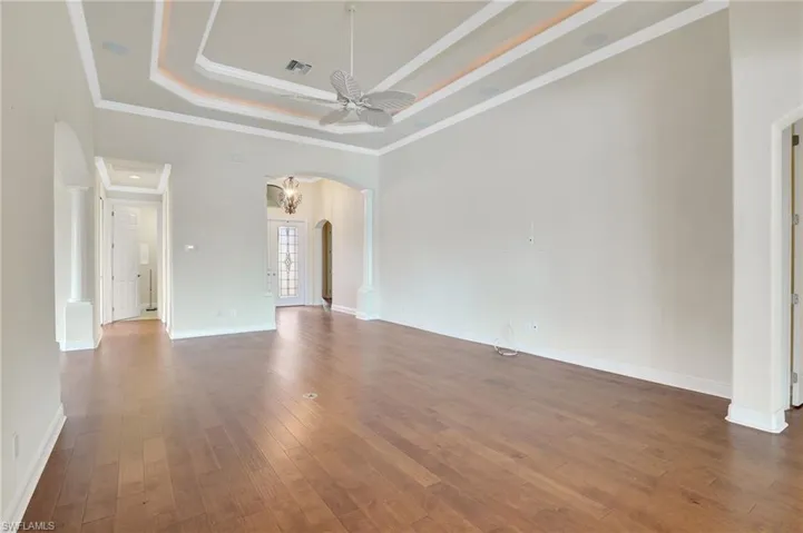 Spare room featuring a raised ceiling, ornamental molding, and hardwood / wood-style flooring