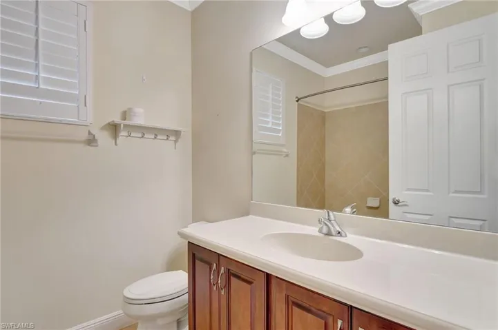 Bathroom featuring toilet, crown molding, and vanity