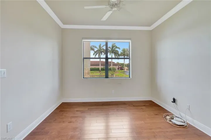 Empty room with ceiling fan, ornamental molding, and hardwood / wood-style flooring