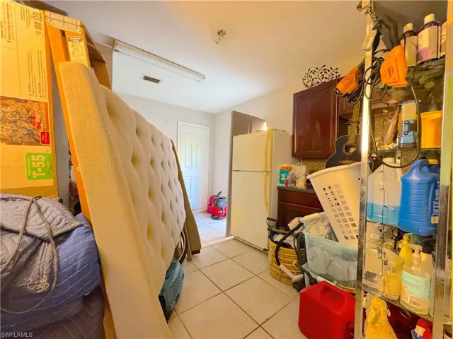 Kitchen featuring light tile patterned flooring and freestanding refrigerator