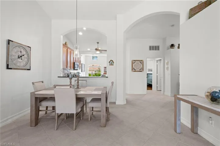 Dining area featuring neutral tile flooring and arched architectural details
