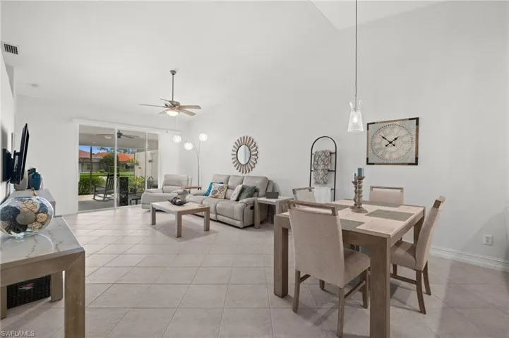 Vaulted ceilings extend over a combined living and dining area with tile flooring throughout