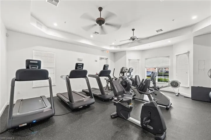 Dedicated fitness area featuring multiple exercise machines, recessed lighting, and dual ceiling fans