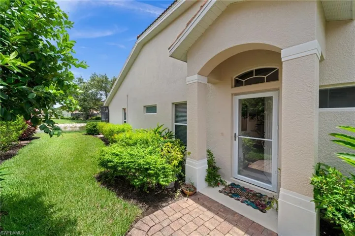 Entryway featuring an arched portico, transom window, and a glass storm door