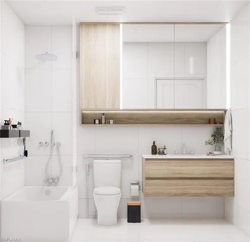 Bathroom featuring vanity, tile walls, tile patterned flooring, and bathing tub / shower combination