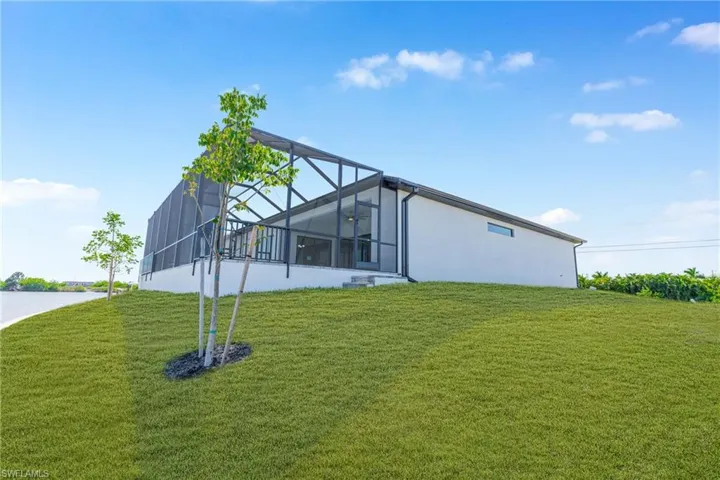 View of property exterior with a yard, a lanai, a sunroom, and a patio