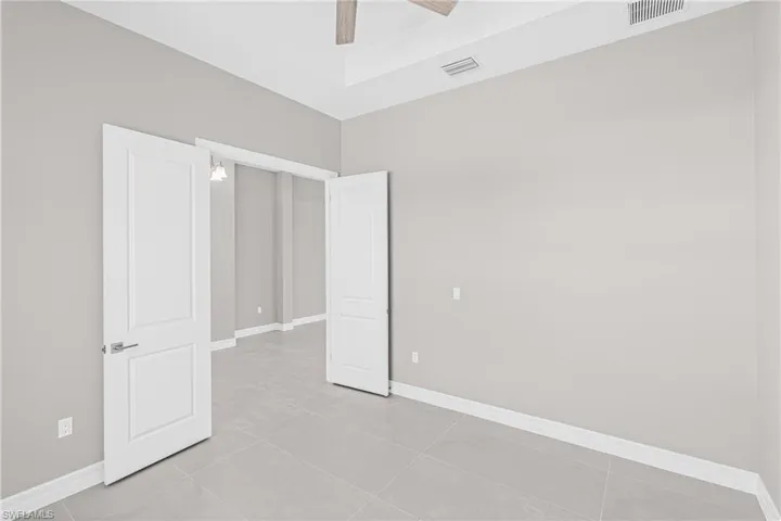 Unfurnished bedroom featuring light tile patterned floors and ceiling fan
