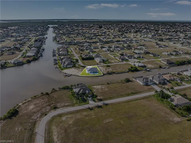 Aerial view of property's location with a nearby body of water and nearby suburban area