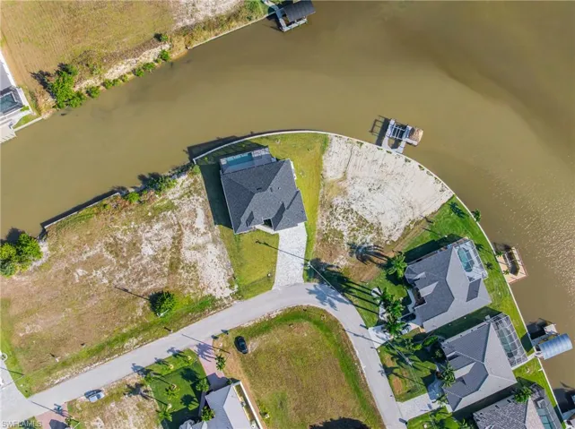 Aerial overview of property's location featuring a large body of water and nearby suburban area