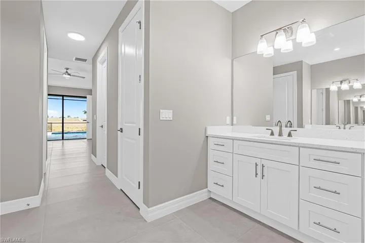 Bathroom featuring vanity, light tile patterned flooring, ceiling fan, and recessed lighting