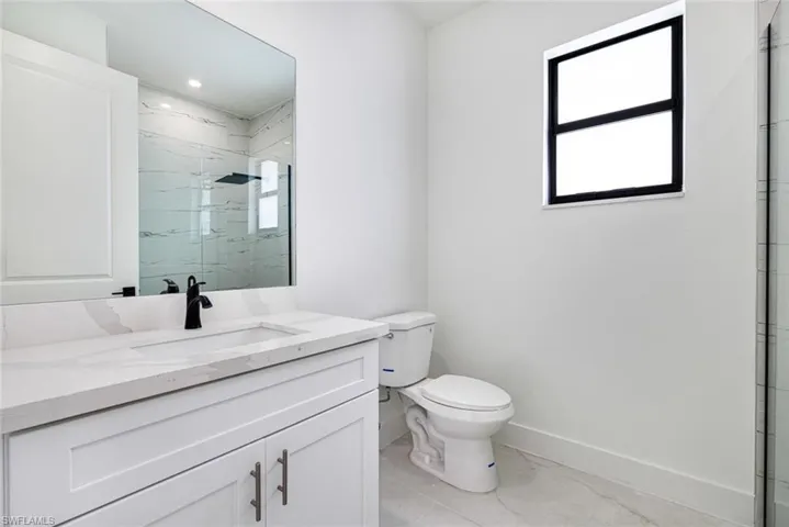 Full bathroom featuring vanity and a marble finish shower