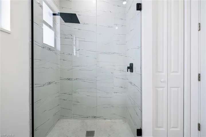 Full bath with a closet and a marble finish shower