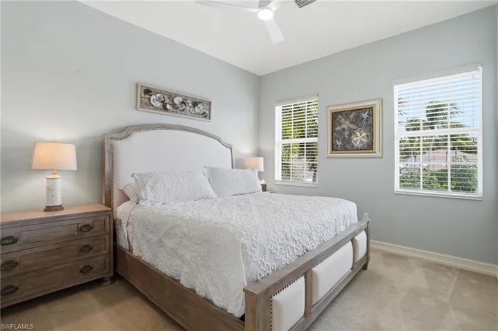 Bedroom with light colored carpet and ceiling fan