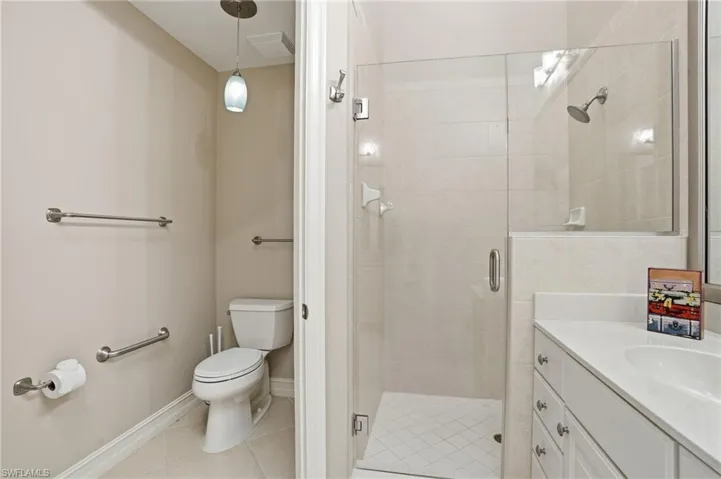 Full bathroom with a shower stall, vanity, and light tile patterned floors