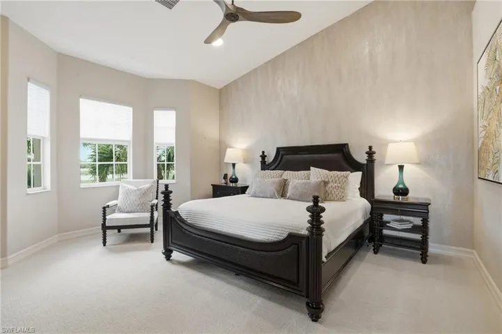 Bedroom with a ceiling fan and light colored carpet