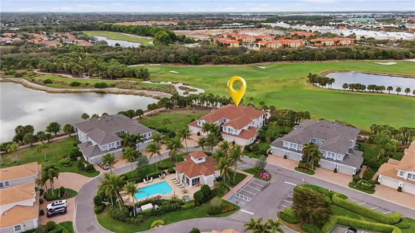 Aerial view of residential area with a nearby body of water and a golf course