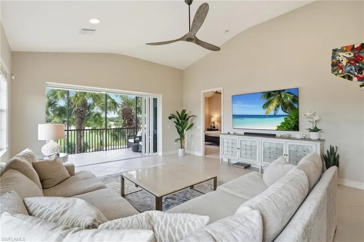 Living room with light tile patterned flooring, a ceiling fan, lofted ceiling, and recessed lighting