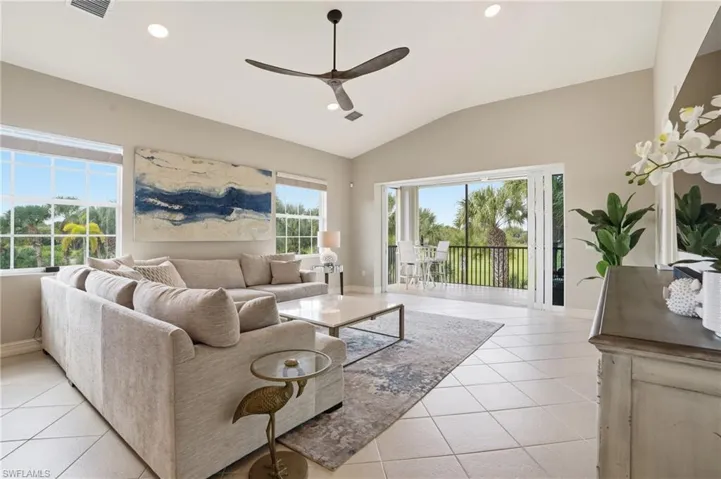 Living room featuring ceiling fan, vaulted ceiling, recessed lighting, healthy amount of natural light, and light tile patterned flooring
