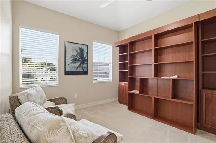 Living area featuring light carpet and a ceiling fan