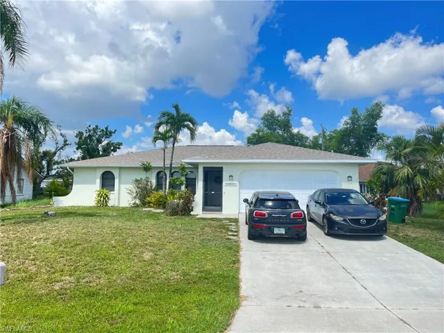 Ranch-style home with stucco siding, a front lawn, concrete driveway, a garage, and roof with shingles