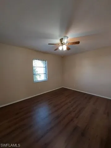 Unfurnished room with dark wood-style flooring
