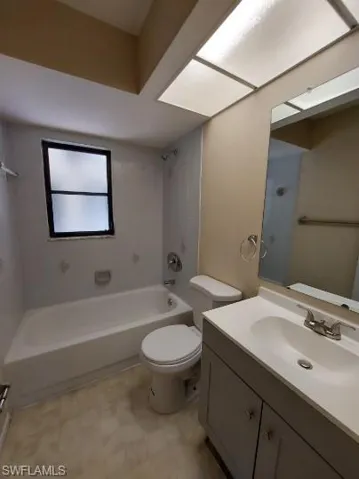 Bathroom with vanity, shower / bathtub combination, and light floors