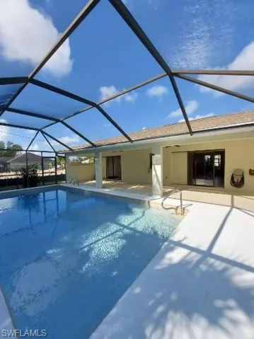 Outdoor pool featuring a sunroom, a lanai, and a patio