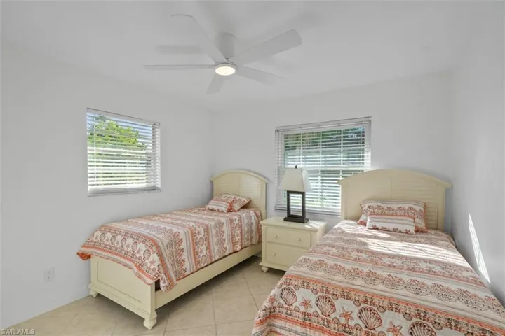 Bedroom featuring multiple windows, a ceiling fan, and light tile patterned floors
