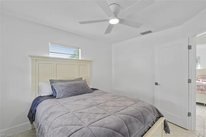 Bedroom with light tile patterned floors and ceiling fan