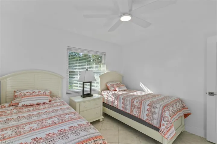 Bedroom with a ceiling fan and light tile patterned floors