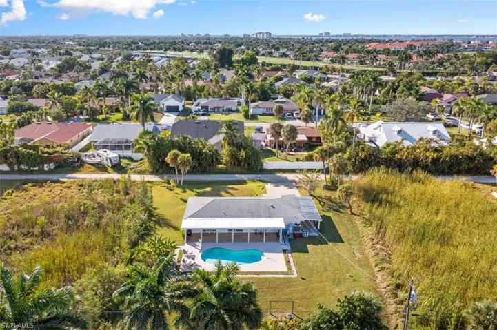 Aerial view of property and surrounding area featuring a pool