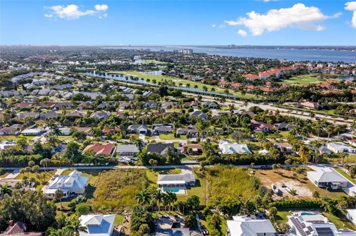 Aerial view of property and surrounding area with a large body of water and nearby suburban area