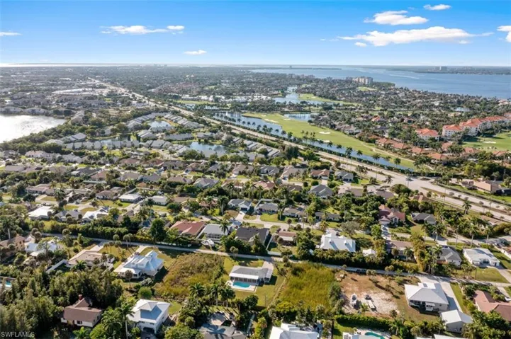 Aerial view of property's location featuring a large body of water and nearby suburban area