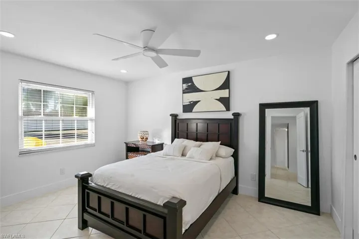 Bedroom with ceiling fan, light tile patterned floors, and recessed lighting