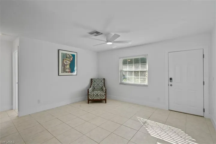 Unfurnished room with ceiling fan and light tile patterned floors