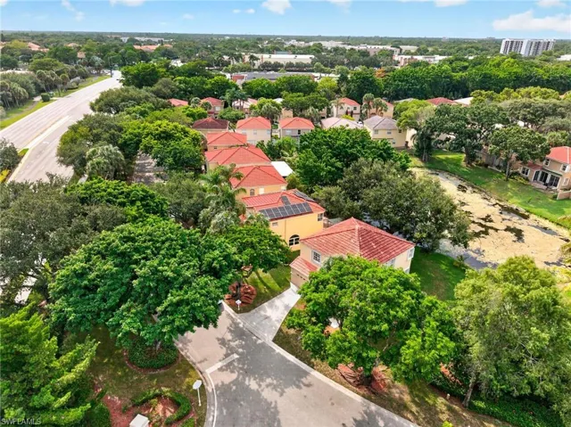 Lush landscaping surrounds the property, featuring a red tile roof and solar panels