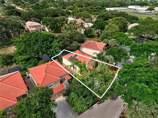 Terracotta tile roof, solar panel array, lush landscaping, and paved driveway
