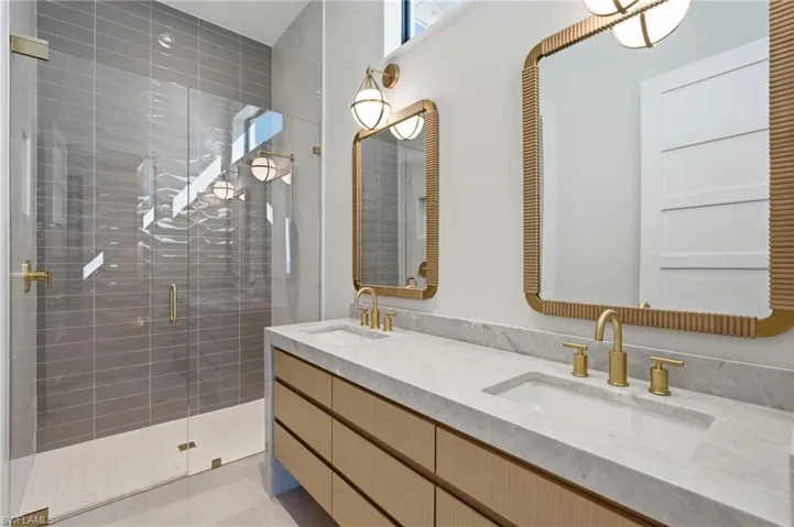 Dual vanity with integrated sinks and gold-finish fixtures set against a white countertop - Virtually Edited Image