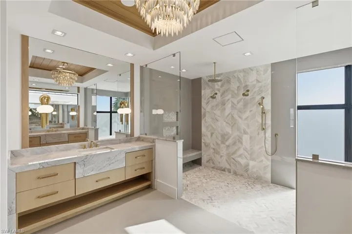 Spacious bathroom featuring a dual vanity with light wood cabinetry and stone countertops - Virtually Edited Image