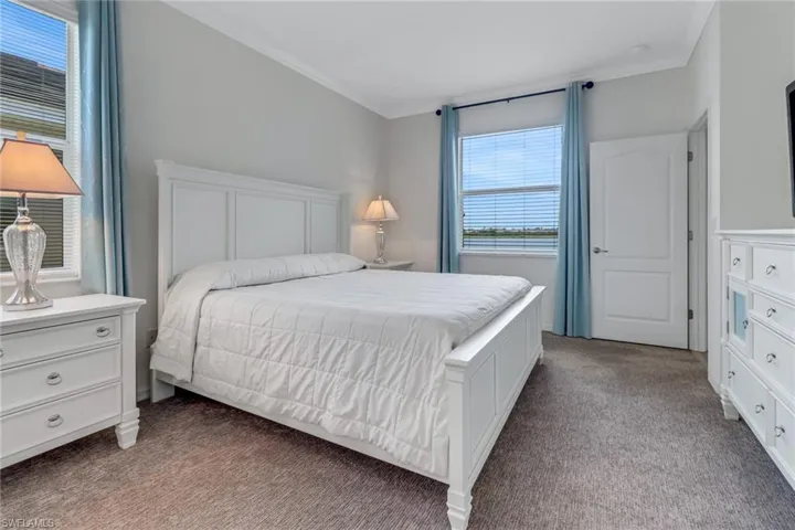 Primary Bedroom with carpet and ornamental molding