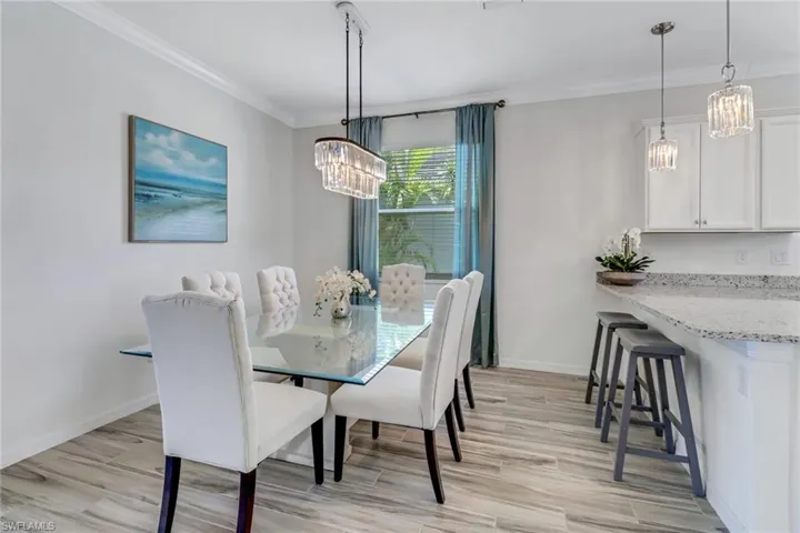 Dining space featuring a chandelier, ornamental molding, and light wood-style flooring