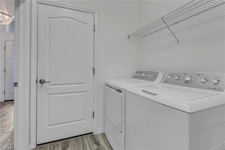 Laundry room featuring washer and clothes dryer and light finished floors