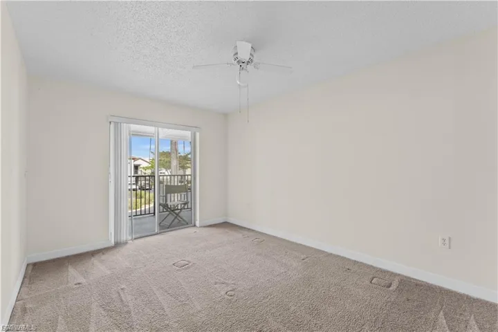 Spare room featuring a textured ceiling, carpet, and a ceiling fan