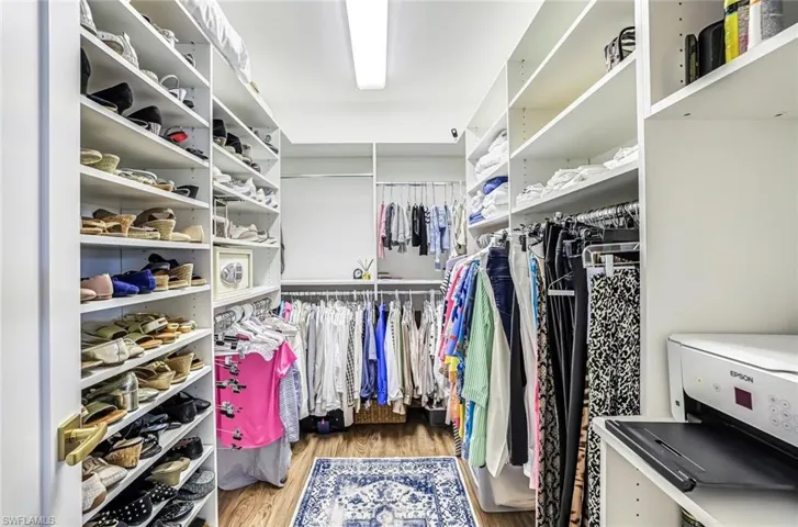 Walk in closet with light wood finished floors