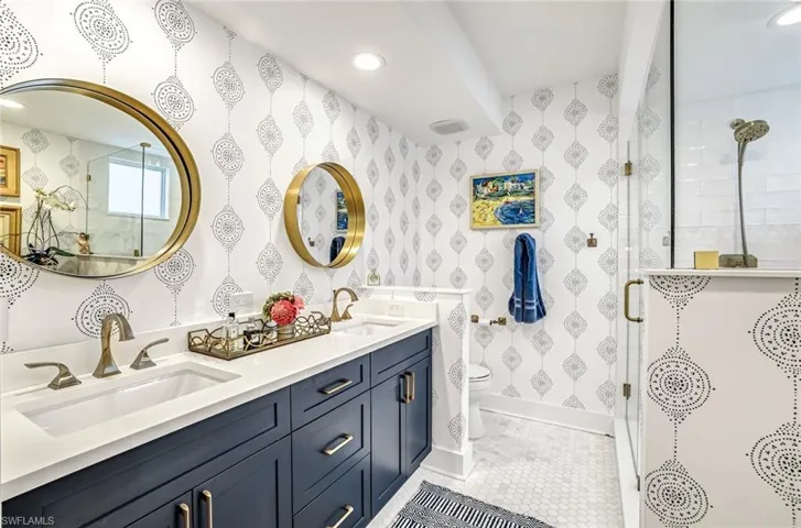 Bathroom with a stall shower, double vanity, recessed lighting, and light tile patterned floors
