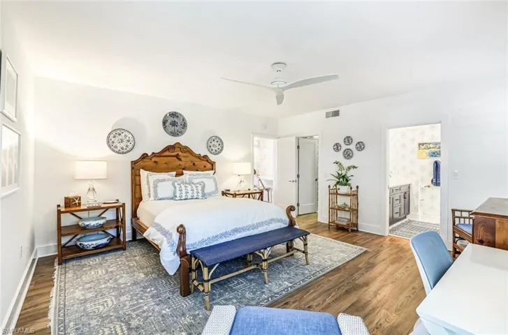Bedroom featuring dark wood-style flooring, a ceiling fan, and connected bathroom