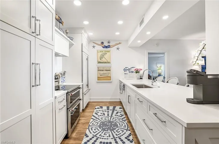 Kitchen featuring white cabinets, recessed lighting, double oven range, a peninsula, and light wood finished floors