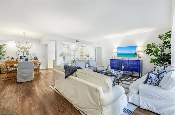 Living room with wood finished floors and suspended lighting