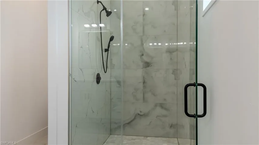 Full bathroom with a marble finish shower