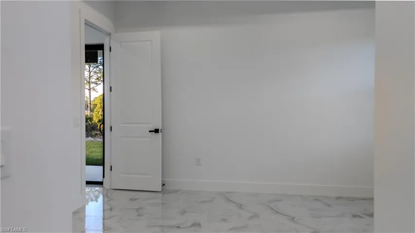 Unfurnished room featuring baseboards and light marble finish floors